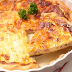 Une part de quiche lorraine dorée et appétissante, prête à être dégustée. La vraie recette quiche lorraine, un délice !