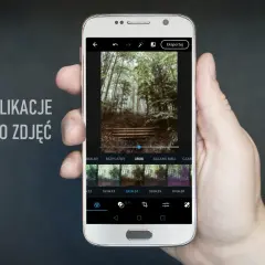 Dłoń trzyma smartfon z aplikacją do edycji zdjęć. Na ekranie widać leśny krajobraz i dostępne filtry, idealne dla fotografów szukających darmowych aplikacji.