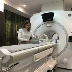 Kobieta przy aparacie MRI, przygotowująca fantom do badań. Praca w dziedzinie fizyki medycznej.