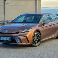 Brązowa Toyota Camry 2.5 Hybrid prezentuje się elegancko, a jej niskie spalanie to atut dla kierowców.