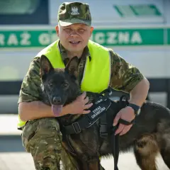 Funkcjonariusz Straży Granicznej z psem, który pomaga w pracy. Psy pracujące to wierni towarzysze na służbie.