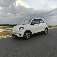 Biały samochód elektryczny na drodze, symbol rosnącej liczby aut elektrycznych w Polsce.