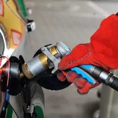 Ręka w czerwonej rękawicy podłącza pistolet do tankowania LPG. To proste tankowanie dla początkujących.