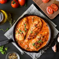 Poitrines de poulet en sauce crémeuse à la tomate, parsemées de persil. Un plat savoureux qui rappelle le poulet chorizo.