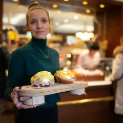 Elegancka piekarnia po francusku prezentuje dwa pączki w płatkach złota.