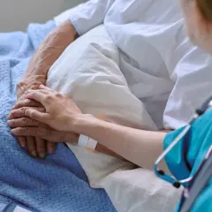 Dłoń pielęgniarki na dłoni pacjenta, symbol wsparcia w leczeniu. Terapia celowana daje nadzieję.