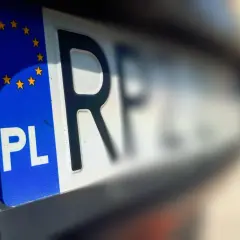 Zbliżenie na polską tablicę rejestracyjną z symbolem UE. To ważny moment, pierwsza rejestracja samochodu.