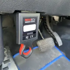 MAXIECU diagnostyczny interfejs do Citroena, podłączony pod deską rozdzielczą, obok pedałów.