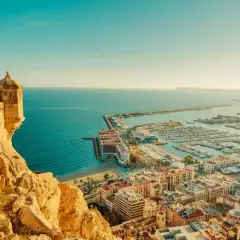 Vista panorámica de Alicante, con su castillo, el puerto deportivo lleno de barcos y el mar azul. Así es cual es la costa blanca.