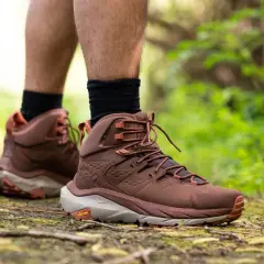 Scarpe da hiking: il loro significato è avventura e comfort su ogni sentiero. Stivali marroni su un sentiero nel bosco.