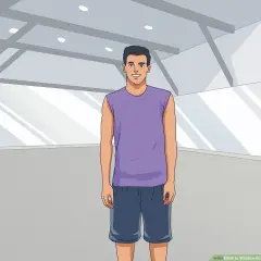 A man in athletic wear stands ready for shadow boxing in an empty gym.