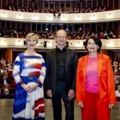 Drei Personen stehen vor einem Publikum im Opernhaus. Ein besonderes oper jahr.