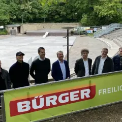 Sieben Männer stehen vor einer Freilichtbühne am Killesberg. Die Banner deuten auf bevorstehende Killesberg Veranstaltungen heute.