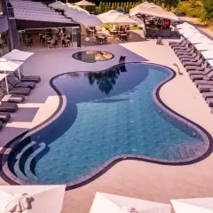 Relaks przy basenie w Laki Hotel & Spa. Leżaki i parasole czekają na gości.