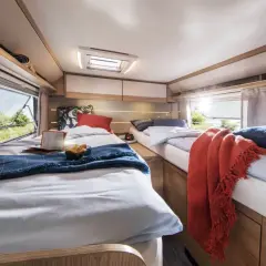 Deux lits jumeaux confortables, aménagés comme un lit à la française, invitent au repos dans ce camping-car lumineux.