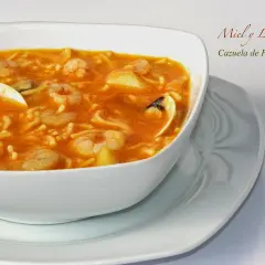 Cazuela de fideos con gambas y mejillones en un cuenco blanco.