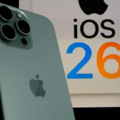 iPhone z systemem iOS 26.3, z widocznym logo Apple i aparatem.