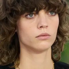 Modelka prezentuje modne fryzury półdługie z grzywką cieniowane, podkreślające jej naturalne piękno.