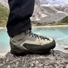 Buty Garmont Vetta GTX na kamieniu, z widokiem na turkusowe jezioro i góry. Gotowe na każdą wyprawę.