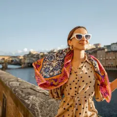 Kobieta w okularach i wzorzystym szalu na tle florenckiego mostu. Popielniczka po włosku, czyli piękny widok.