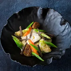 Parmentier de patata con espárragos, zanahorias, morillas y láminas de trufa negra.
