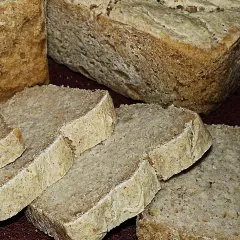 Pokrojony na kromki chleb bez glutenu, z widoczną strukturą miękiszu i chrupiącą skórką. Idealny dla osób na diecie bezglutenowej.