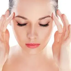 Donna con le mani sulle tempie, soffre di mal di testa da stress. Scopri come farlo passare con rimedi naturali.