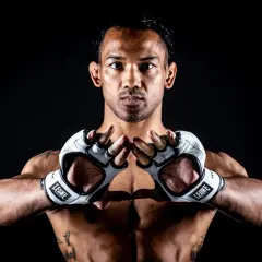 Benson Henderson, en fighter redo för strid, med vita handskar och intensiv blick.