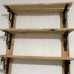 Scaffali in legno fai da te, con staffe nere decorative, perfetti per un tocco rustico.
