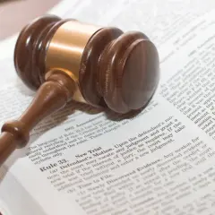 Młotek sędziowski na otwartej księdze prawnej. Symbolizuje zbrodnię i karę znaczenie tytułu, gdzie prawo decyduje o losie.