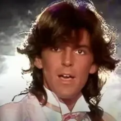 Thomas Anders z burzą włosów i w jasnej koszuli z krawatem.