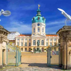 Pałac Charlottenburg w stylu rokoko, z bramą i posągami strażników.