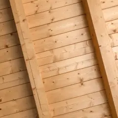 Holzdeckenpaneele mit sichtbaren Balken, bereit zum Streichen. Natürliche Holzmaserung.