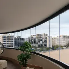 Modernas ideas para cerrar balcones: un espacio acogedor con silla colgante y vistas urbanas.
