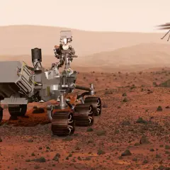 Łazik na Marsie przygotowuje się do misji Mars Sample Return, podczas gdy mały helikopter lata nad czerwoną pustynią.