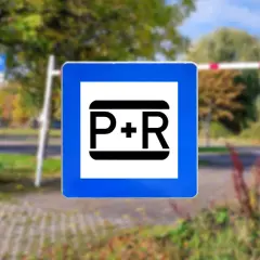 Blaues Schild mit weißem Quadrat und schwarzem "P+R" Symbol. Dieses Parken und Reisen Schild weist auf eine Park & Ride Anlage hin.