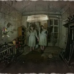 Dwie dziewczynki w starym pokoju, jak z domu strachu. W tle łóżeczko, szafa i okno.