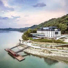 Elegancki hotel nad jeziorem, idealny na romantyczne miejsca w Polsce. Widok z lotu ptaka na architekturę i naturę.