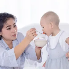 Madre alimenta a su bebé con cuchara. Mi bebé come bien pero no engorda, aunque se ve feliz y saludable.