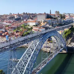 Most Ponte Dom Luís I w Porto, z widokiem na rzekę Douro i kolorowe budynki.