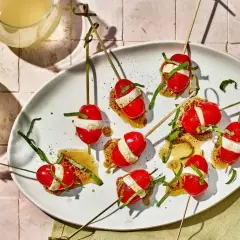 Proste przepisy na przekąski w 15 minut: szaszłyki caprese z pomidorków, mozzarelli i bazylii na chrupiącym grzanie.