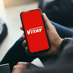 Dłoń trzyma smartfon z czerwoną kartą VITAY.