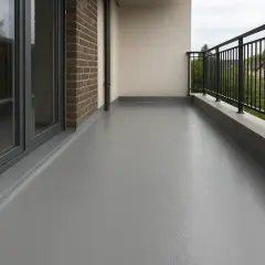 Szary, gładki balkon z płynną membraną dachową, z ceglaną ścianą i metalową balustradą.