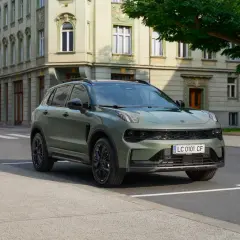 Zielony Lynk & Co SUV zaparkowany na ulicy przed zabytkową kamienicą.