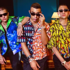 Tre ragazzi con camicie colorate e occhiali da sole, un'immagine che evoca lo stile della dark polo gang.