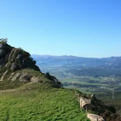 Ascenso al Pico da Frouxeira, con escaleras de madera y vistas panorámicas de valles verdes y montañas.
