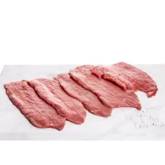 Fettine di vitello pronte per gustose ricette. Carne fresca su tagliere di marmo con sale grosso.