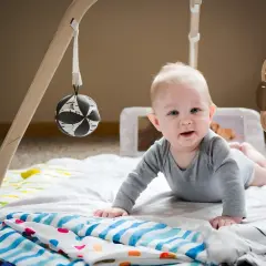 Söt bebis på en babygym med kant, redo att utforska leksakerna.