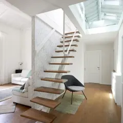 Scala interna moderna in legno e metallo, con design a sbalzo. La normativa scale interne uso privato è rispettata, garantendo sicurezza e stile.
