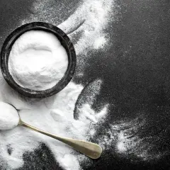 Biały proszek w miseczce i na łyżce to soda oczyszczona. Pomaga w kuchni, sprzątaniu i jako domowy środek leczniczy.